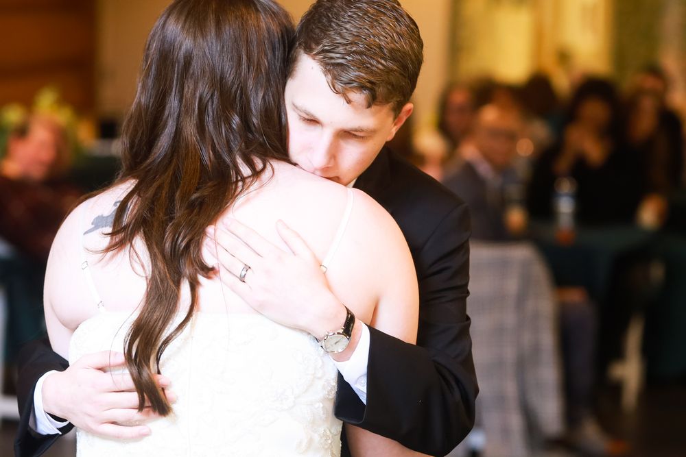 Bride and groom share an emotional first dance embrace at their wedding reception.