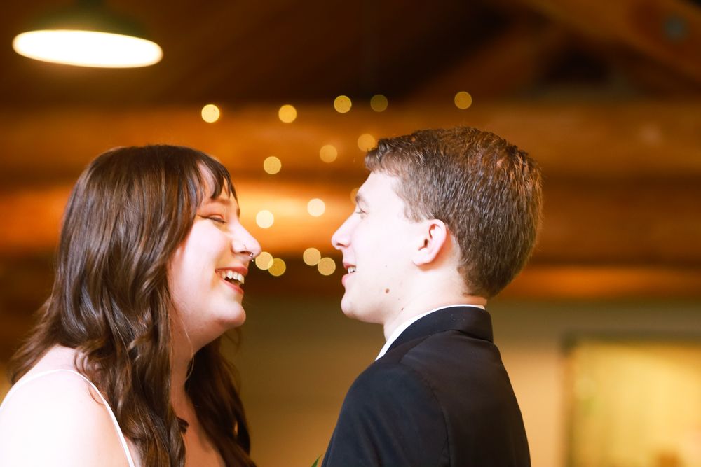 A smiling bride and groom share a joyful moment together at their wedding reception.