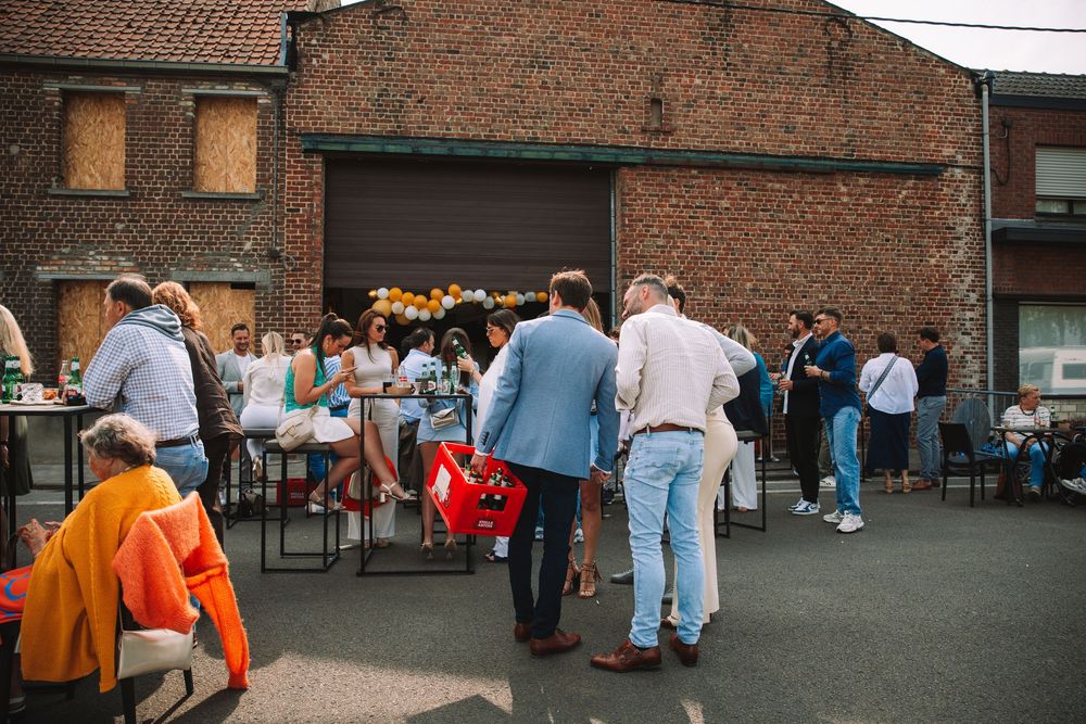 Mensen die buiten zitten aan tafels tijdens een communiefeest.