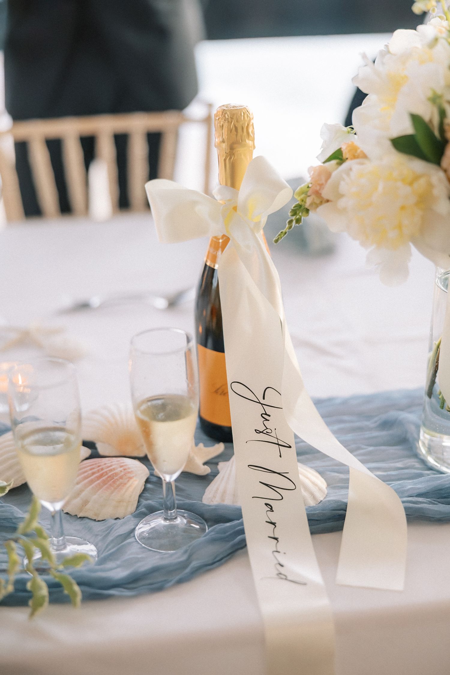 Elegant wedding reception styling featuring champagne, coastal-inspired décor and fresh flowers at Arriba by the Sea in Cascais.