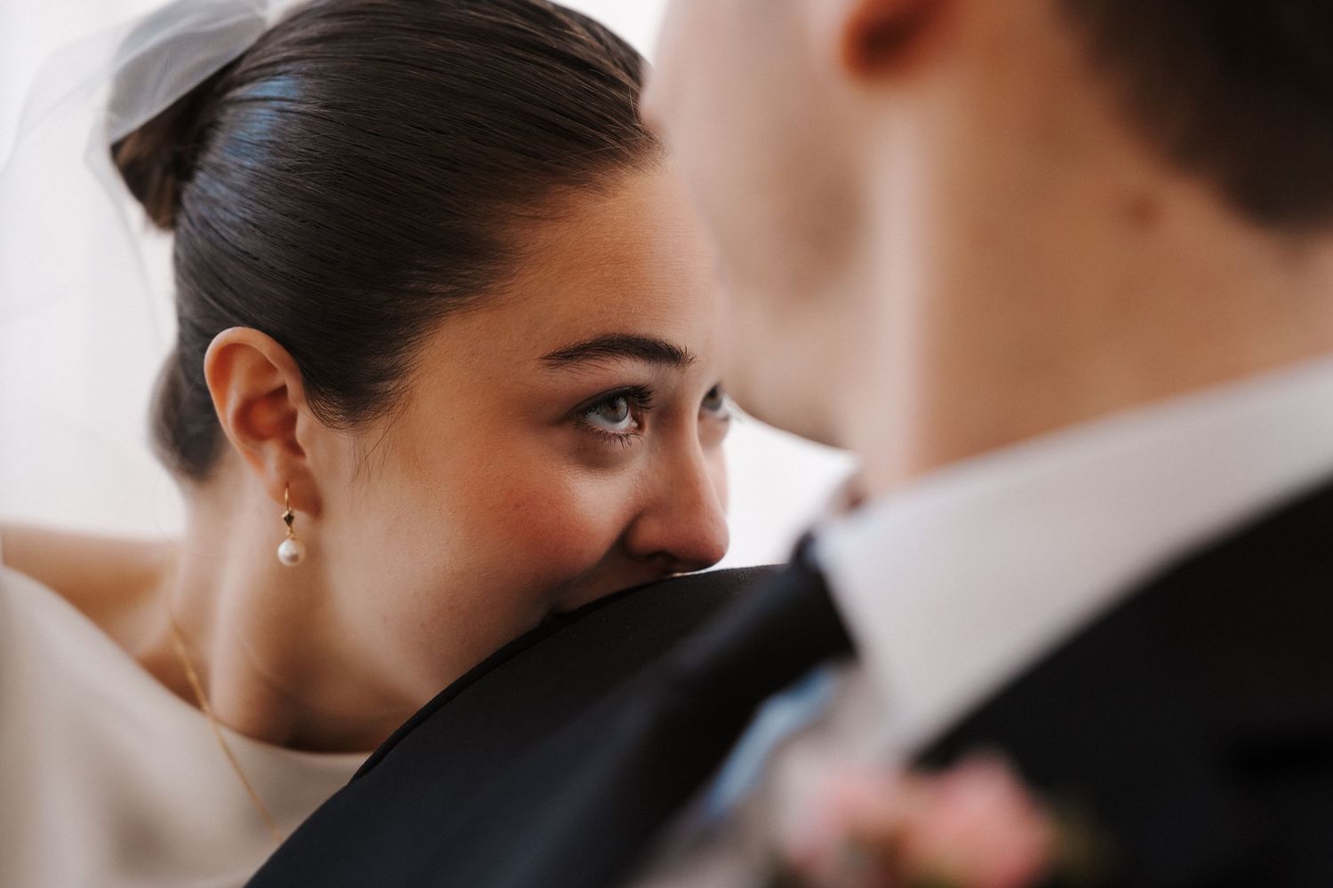 Bride in white veil gazes lovingly at groom in black suit during intimate wedding ceremony moment at the 210 in Pioneer Square.