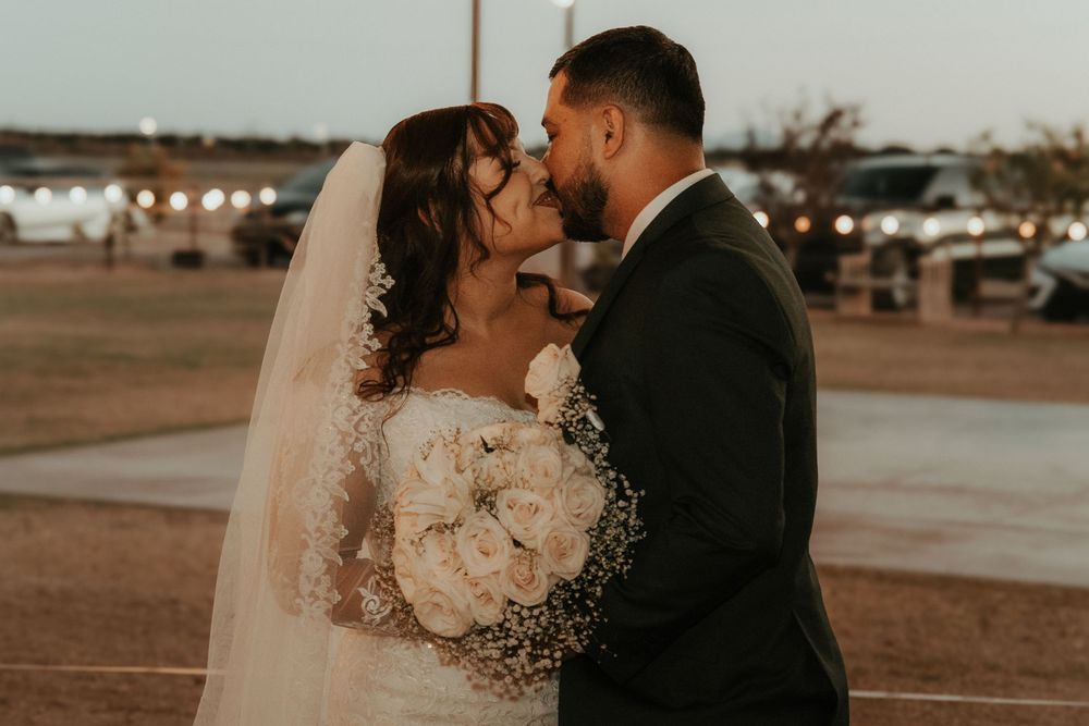 A couple shares an intimate moment at sunset during their desert wedding celebration.