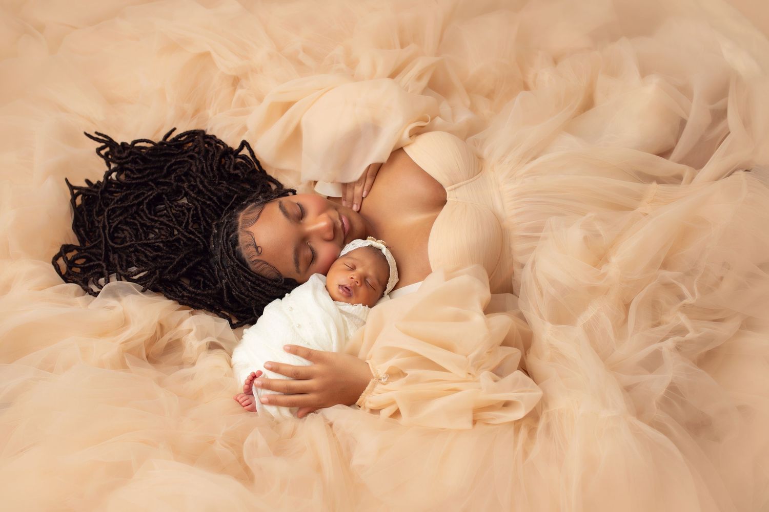 Newborn baby wrapped in orange knit swaddle and bonnet, sleeping in a metal bucket with fall leaves and pumpkins.