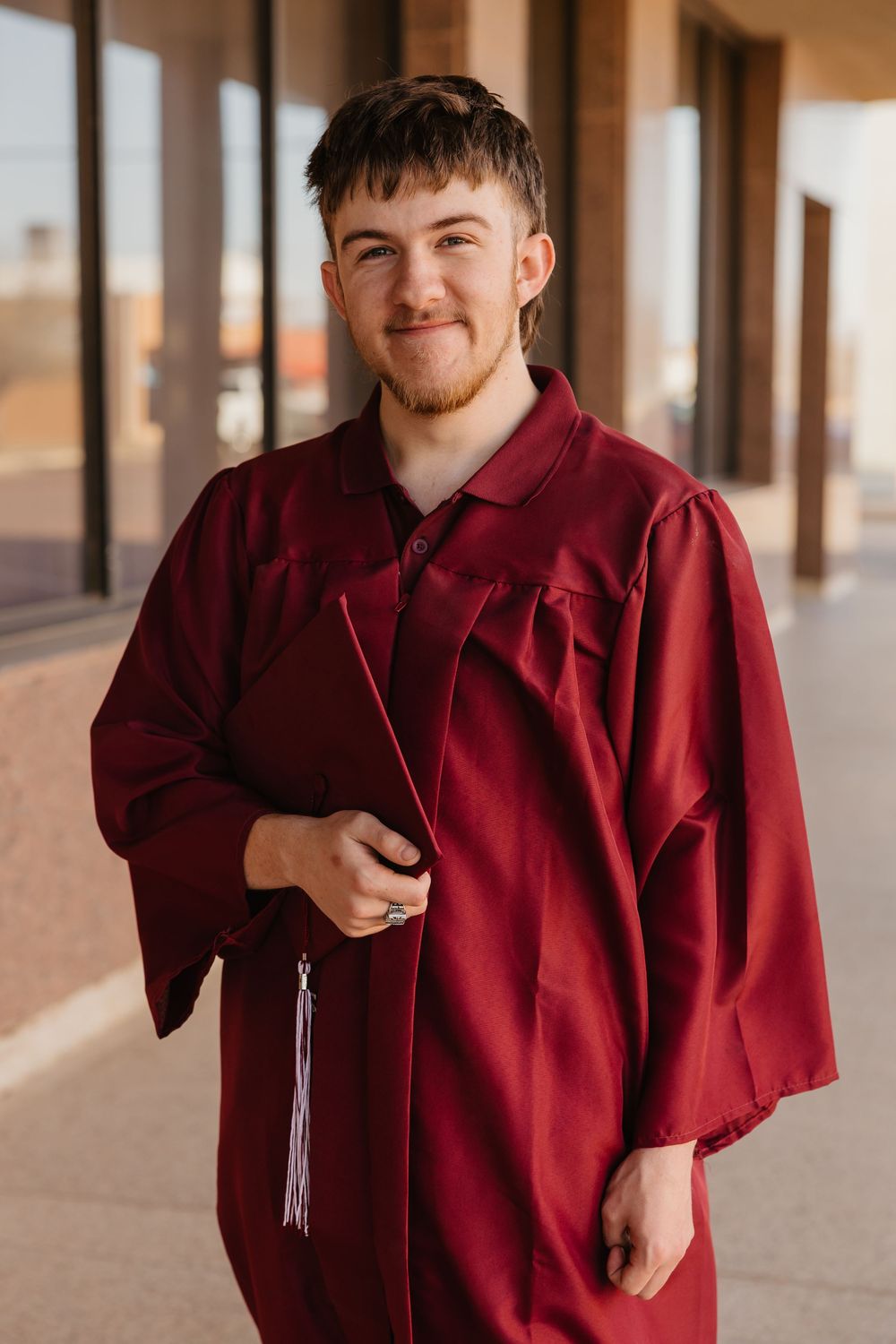 Senior photos for a boy wearing his cap and gown in Tulia Texas