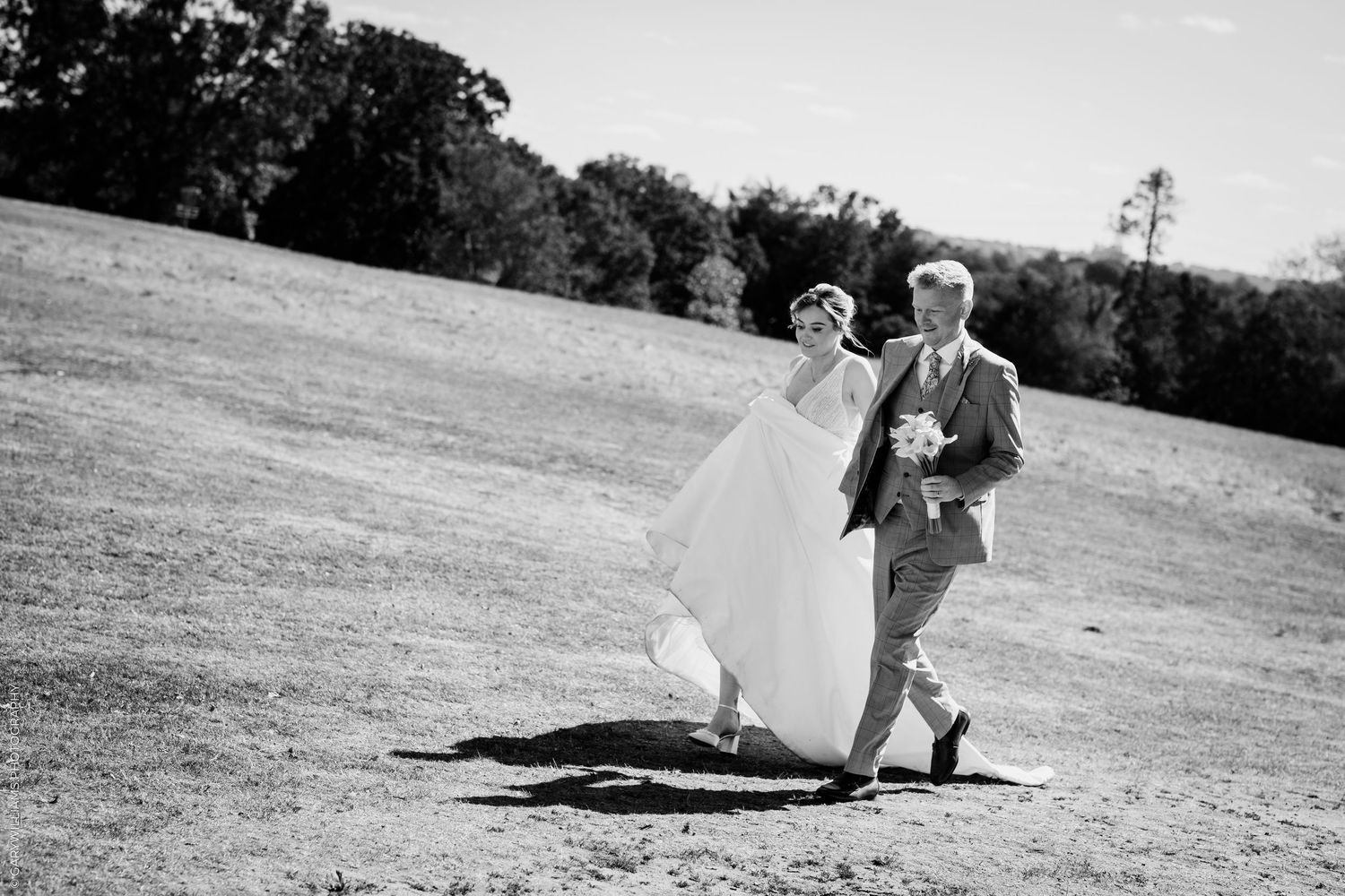 A series of black and white wedding photos showing a bride in a ballgown and guests at an elegant indoor reception.