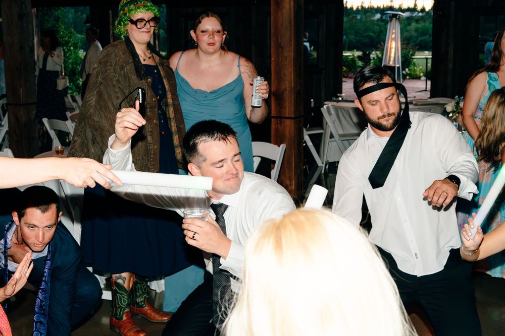 Guests dancing and celebrating at a lively indoor wedding reception party.