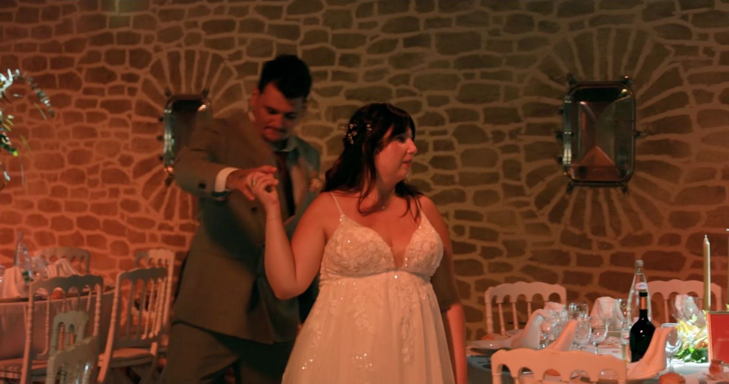 Justine et Ludovic dansent dans la salle en pierre du Château de Roquefeuille, image extraite de leur film de mariage.