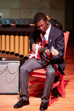 Seated student participating in the St Alban’s music recital programme.