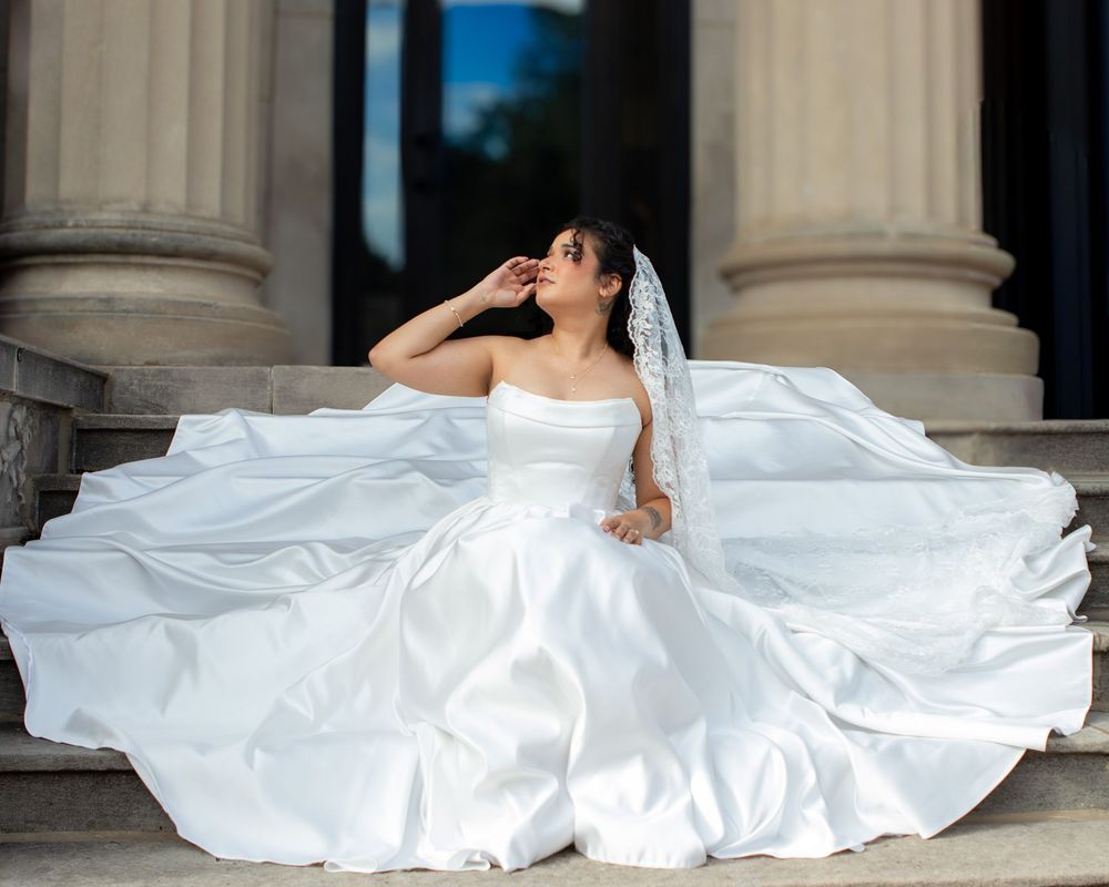 Gorgeous bride in a satin gown sitting on the steps of a church for her strongsville wedding by wedding photographer, Taylor LeAnn Photo.