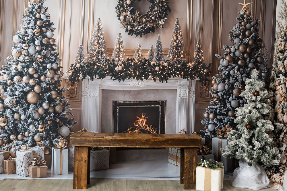 Elegant Christmas fireplace with decorated trees, wreath, ornaments, gifts, and wooden bench in cozy holiday setting.