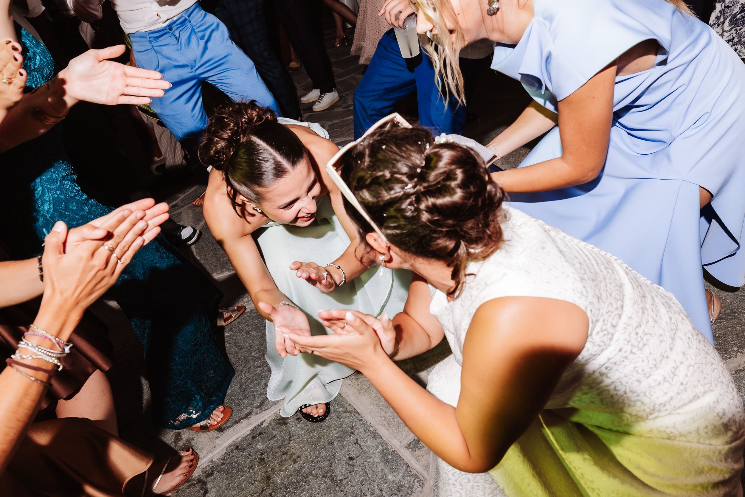 Bride and guests joyfully dancing together at a lively wedding reception celebration.
