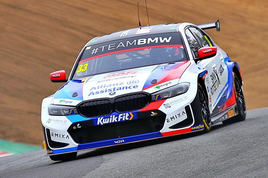 Team BMW racing car number 33 with KwikFit sponsorship competing on a race circuit.