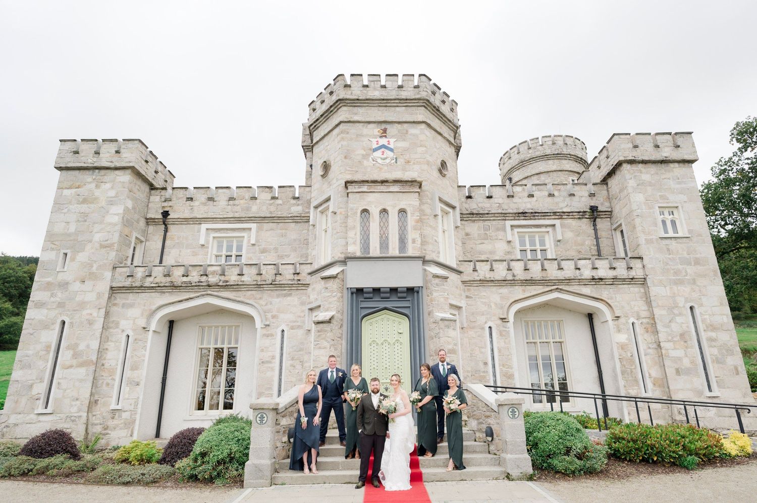 Wedding party outside the stone facade of Killeavy Castle Estate.