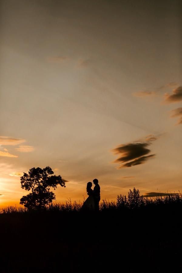Couple silhouetted against a golden sunset on their wedding day