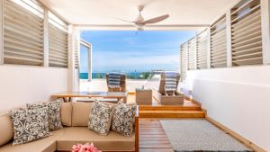 Coastal living room with ocean views, louvered windows, and comfortable seating overlooking the water.