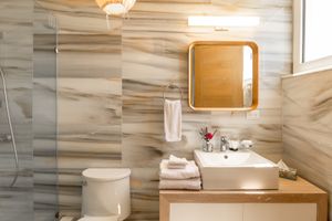 Elegant bathroom with marble-look walls, floating vanity, and modern fixtures.