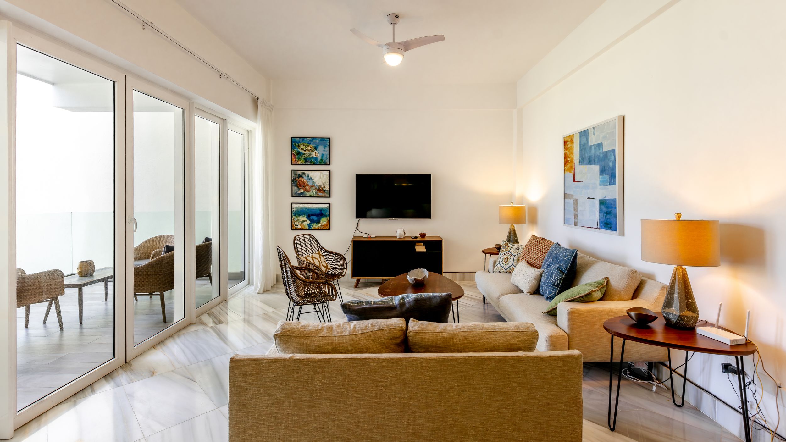 Modern coastal living room with sliding doors, beige sofa and ocean view.