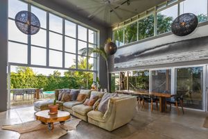 Bright living area with floor-to-ceiling windows, comfortable seating, and natural light flooding the space.