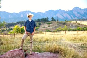 Person standing on rock with scenic mountain vista behind them.