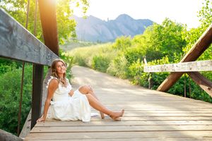 Beautiful mountain landscape with wooden bridge walkway in golden sunlight with white dress and summer atmosphere.