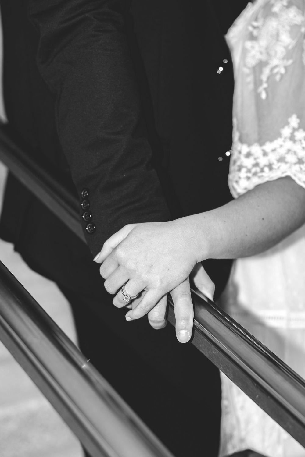 Black and white close-up of couple holding hands—wedding detail photo by Carson Suttle Photography