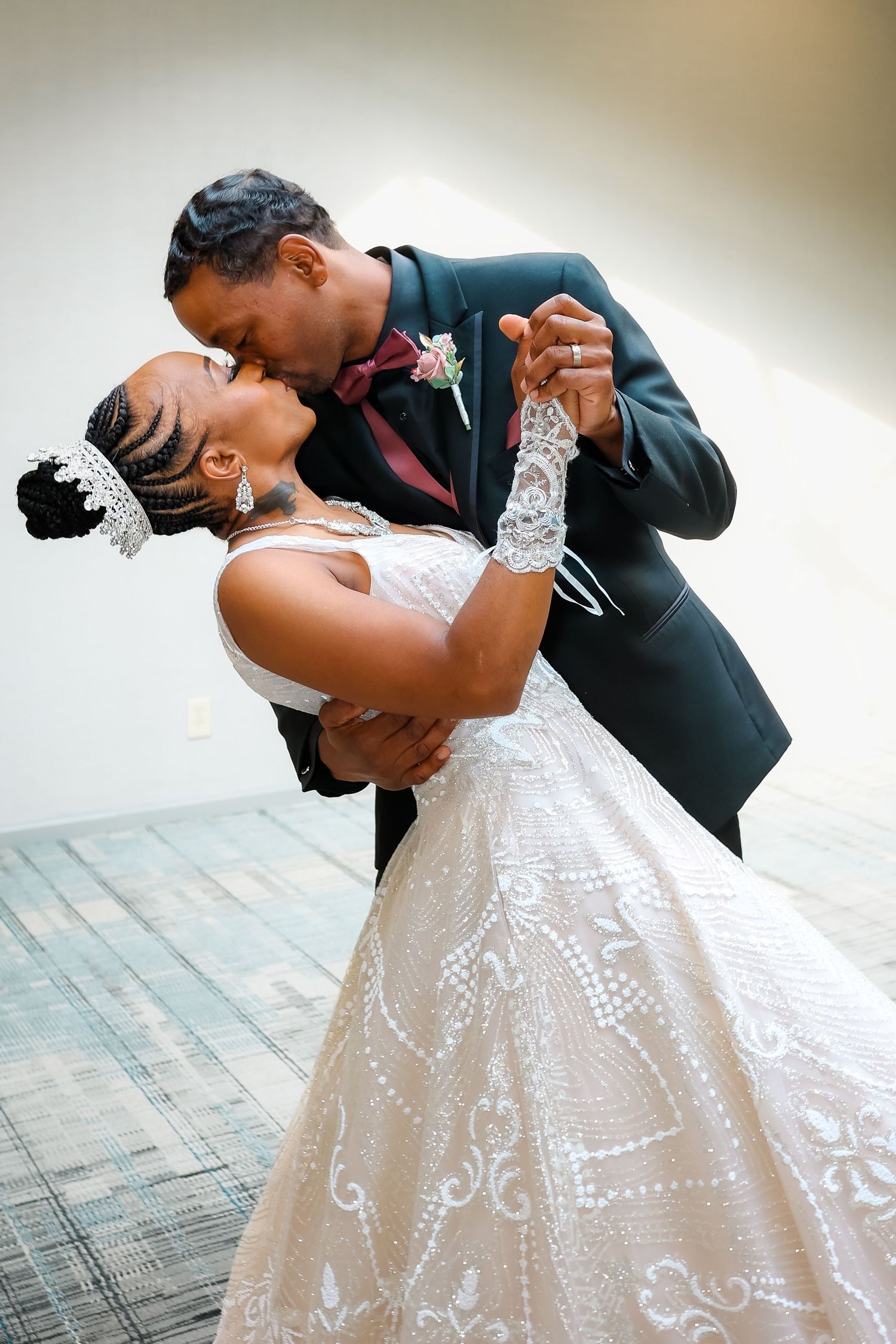 Bride and groom embracing and kissing on wedding day while groom dips bride.
