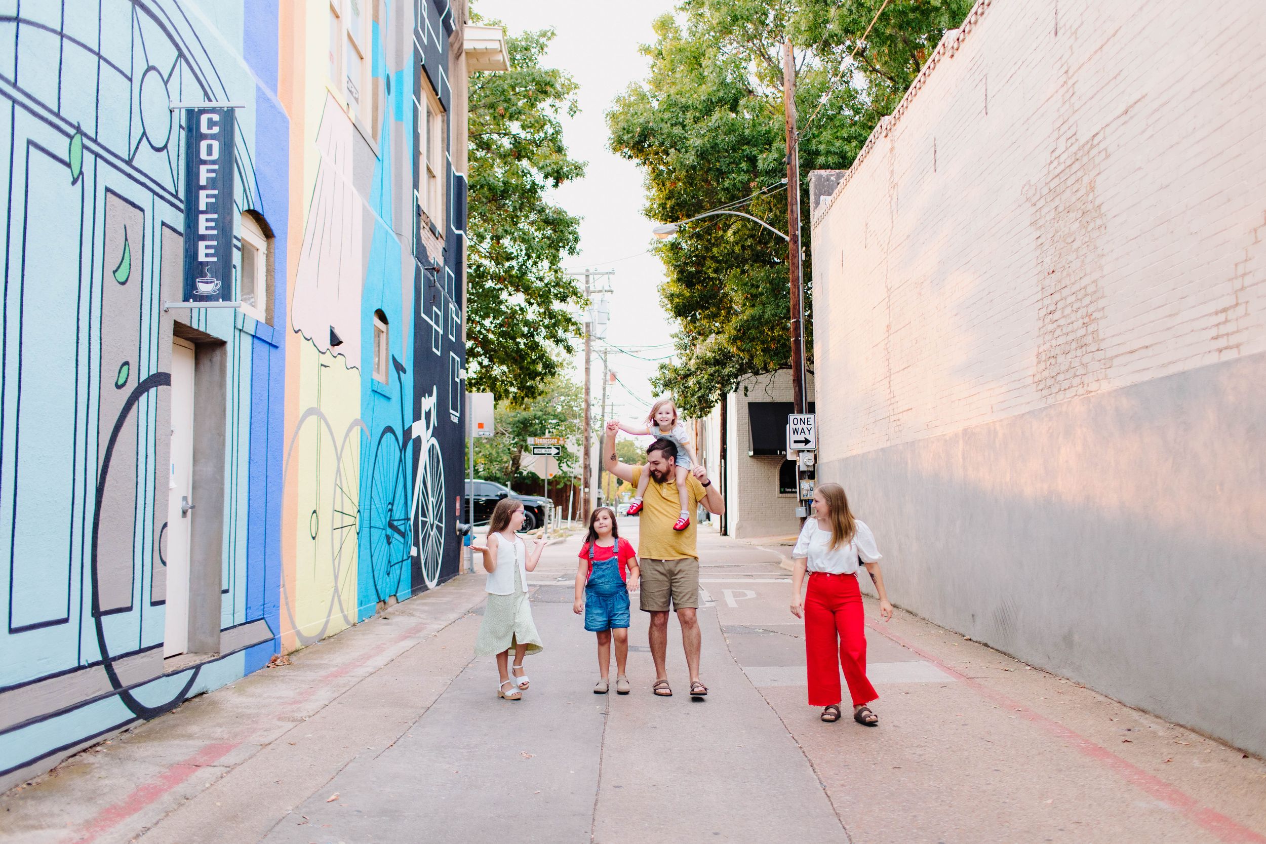 Family dressed in bold colors during an urban outdoor session in Downtown McKinney, TX.