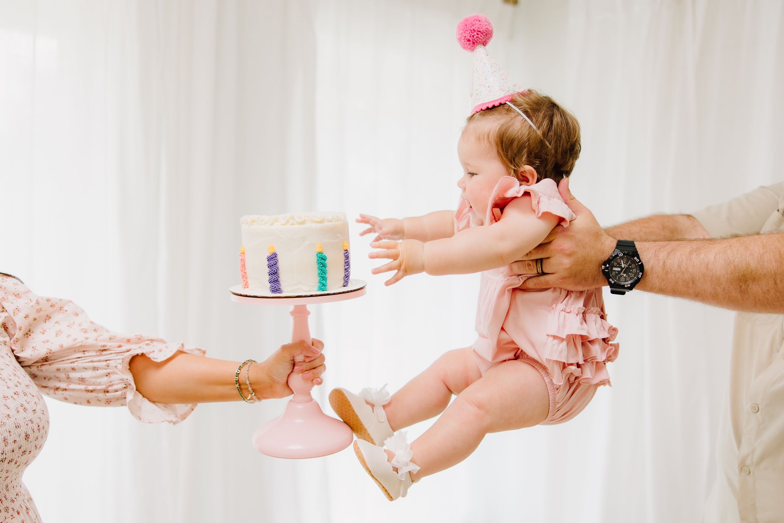 A little girl grabbing for her cake during her cake smash session in Plano, TX.