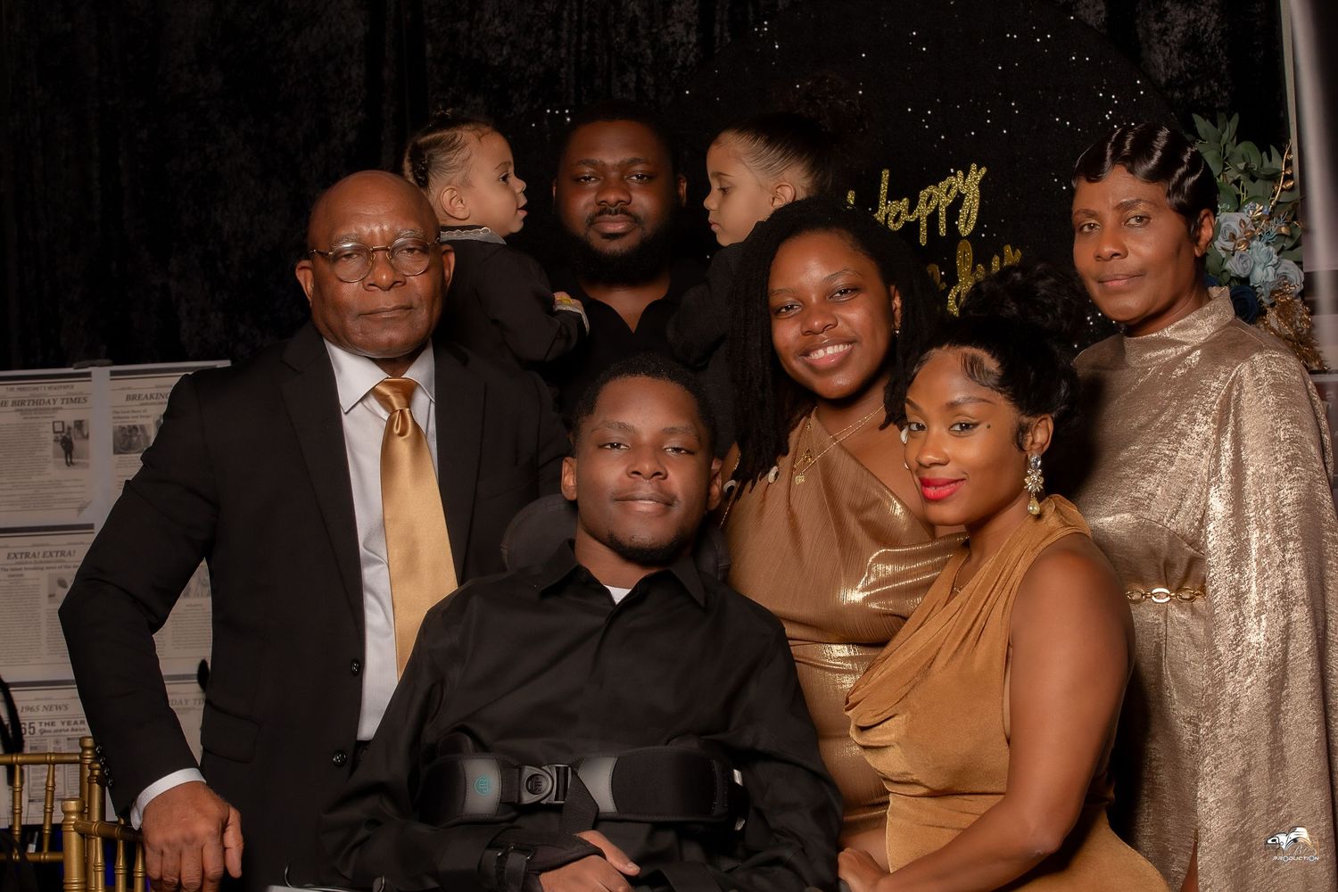 A group poses together for a celebratory photo against a sparkly black backdrop.