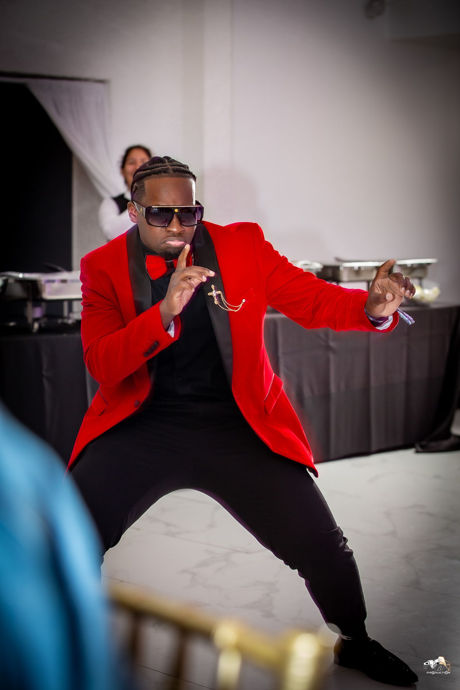 Entertainer in red blazer striking dynamic pose during performance.