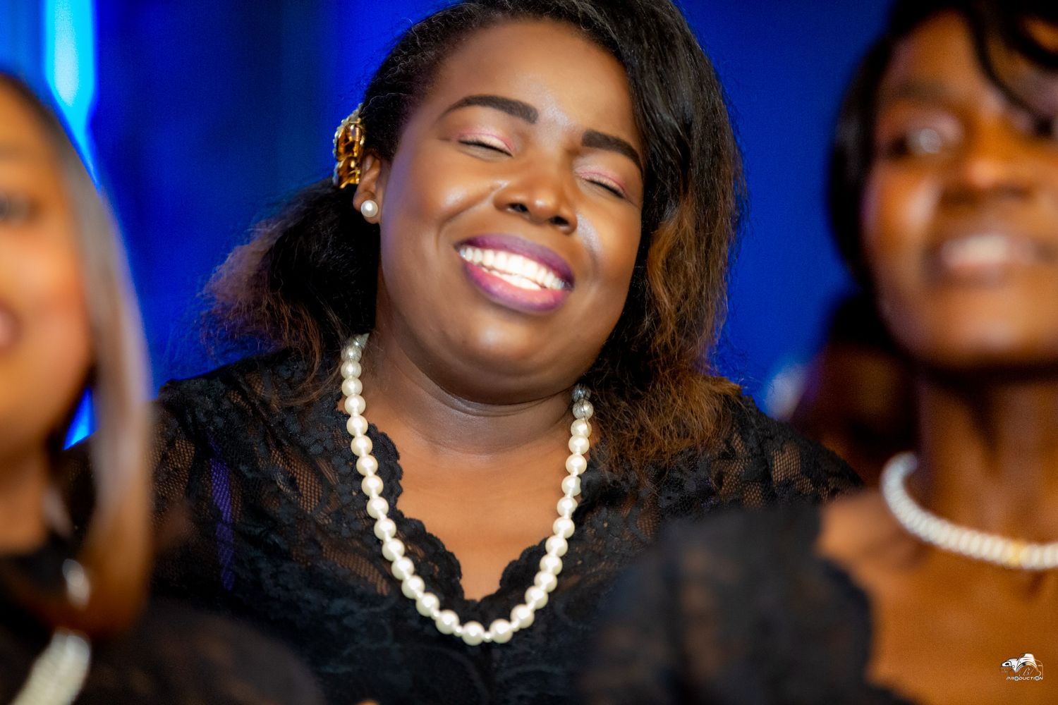 A joyful moment captured during a gospel performance with blue stage lighting.