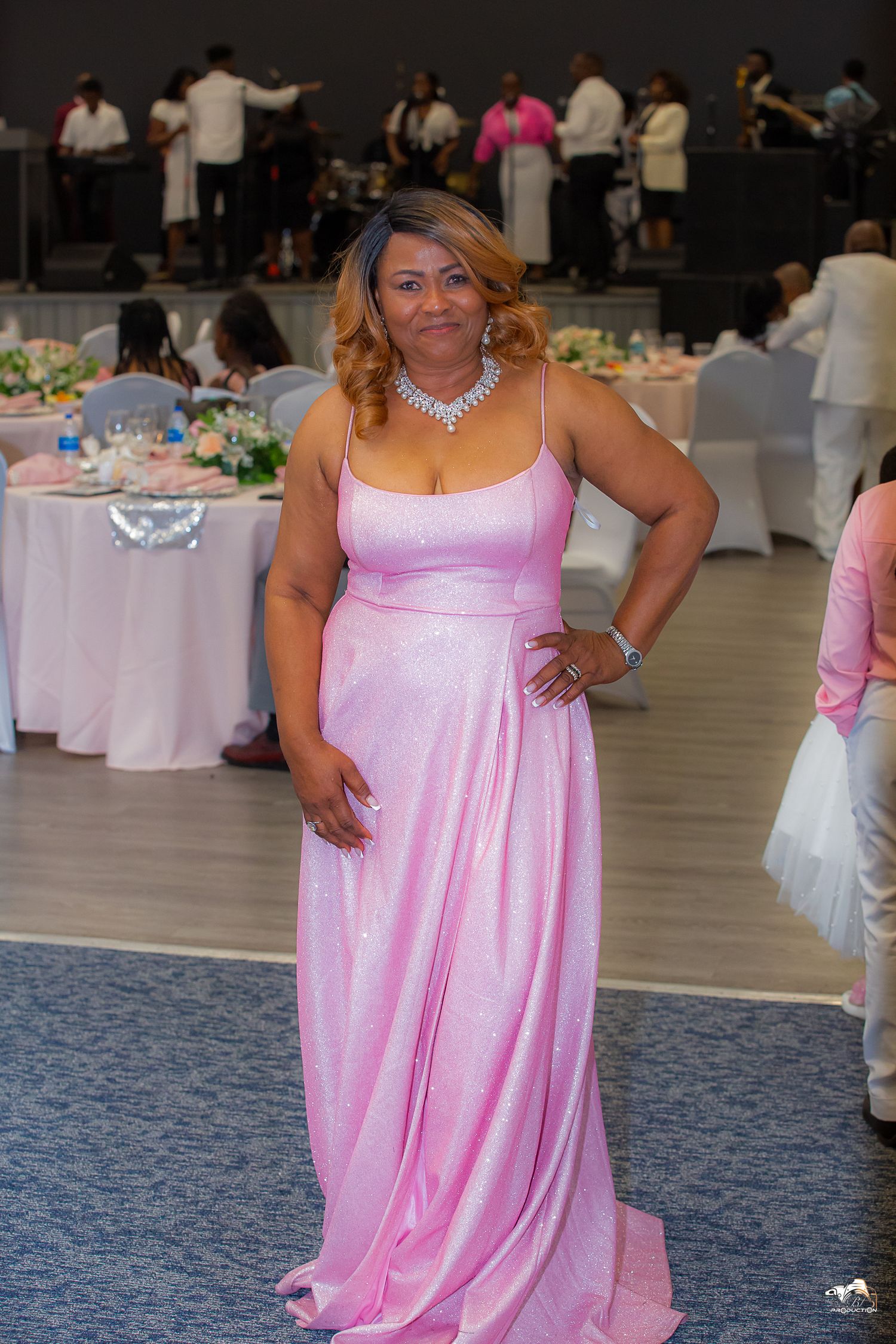 A person in a pink satin evening gown poses at a formal event.