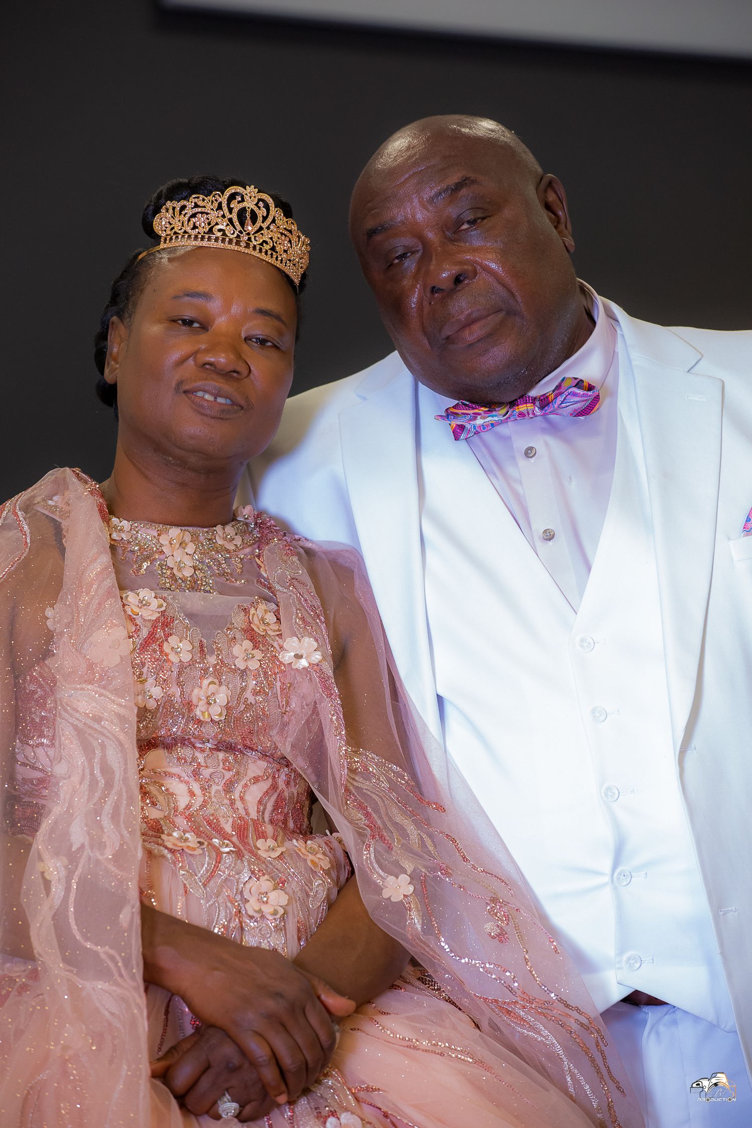 A couple in formal attire pose together at their wedding celebration.