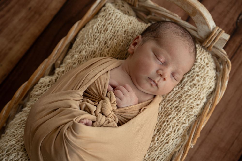 Posed newborn photography of baby in a basket.