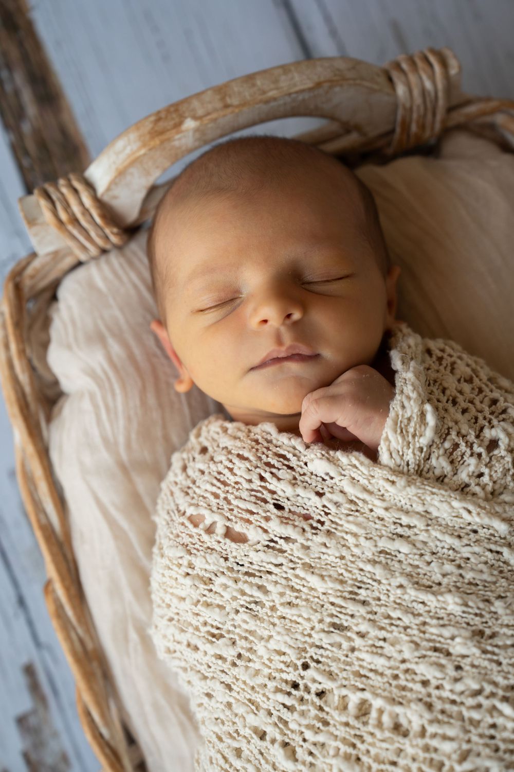 Newborn baby boy swaddled in a basket