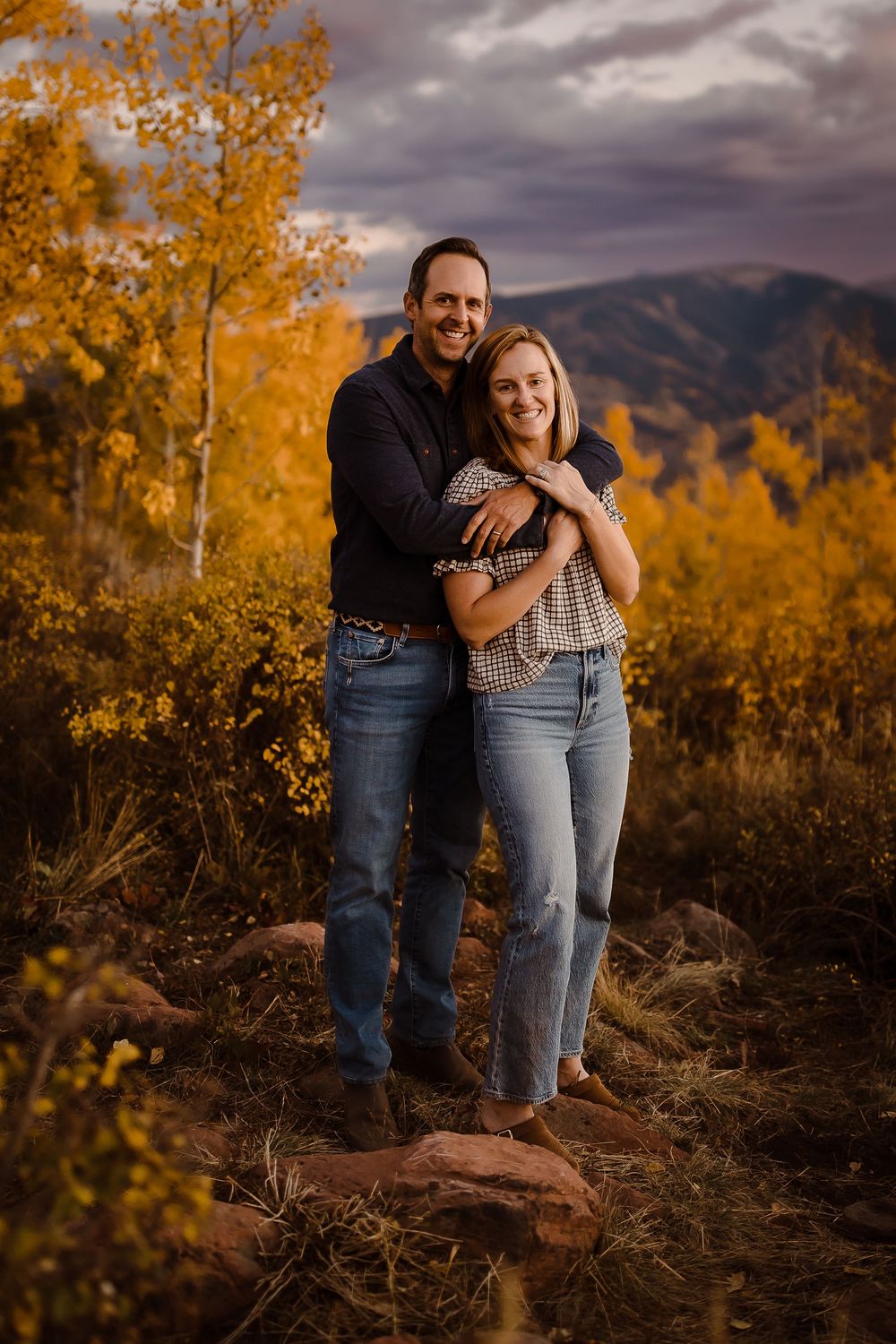 Couple posing happily at dusk in front of yellow Vail aspen leaves