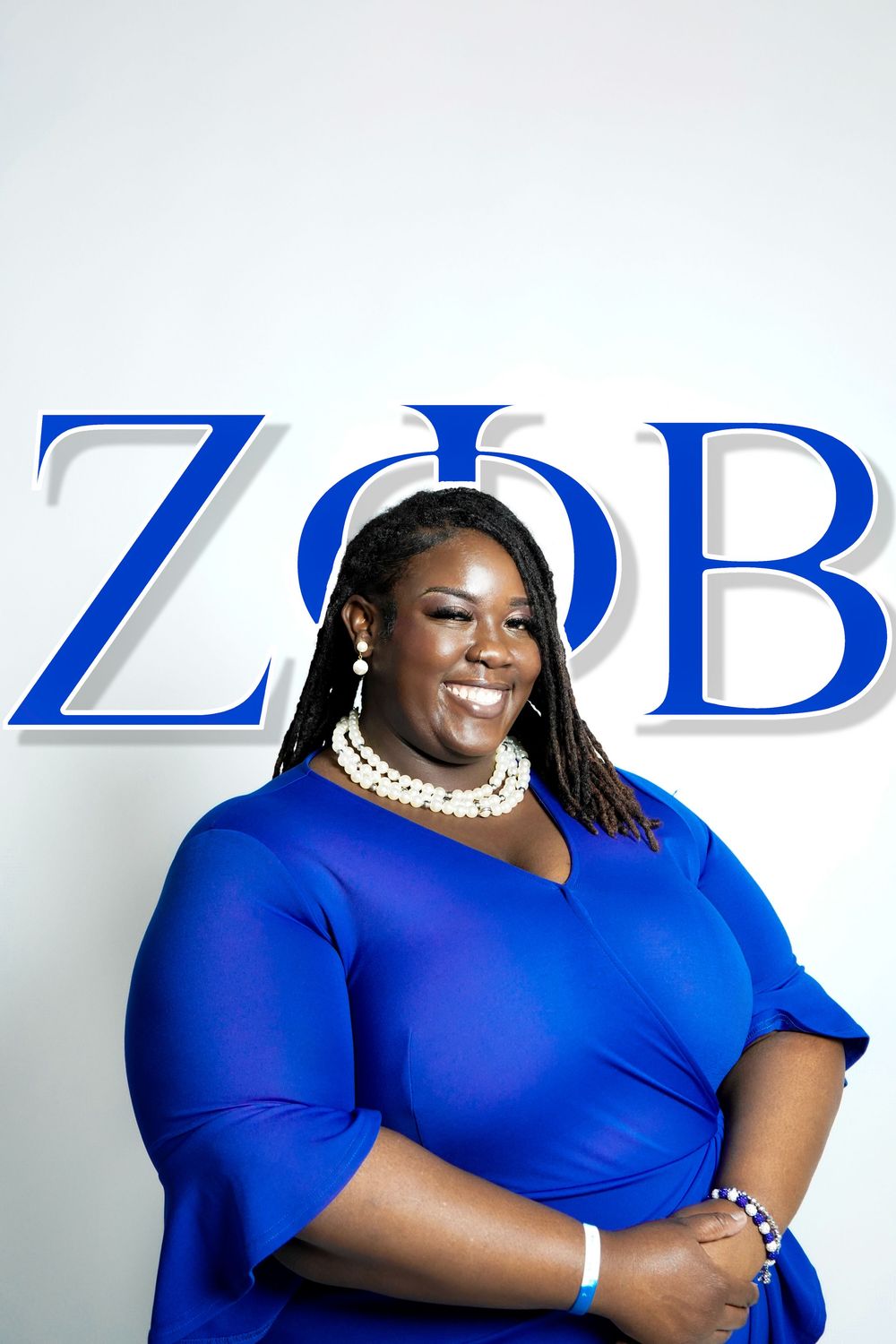 Woman in bright blue outfit posing in front of ZOB text logo.