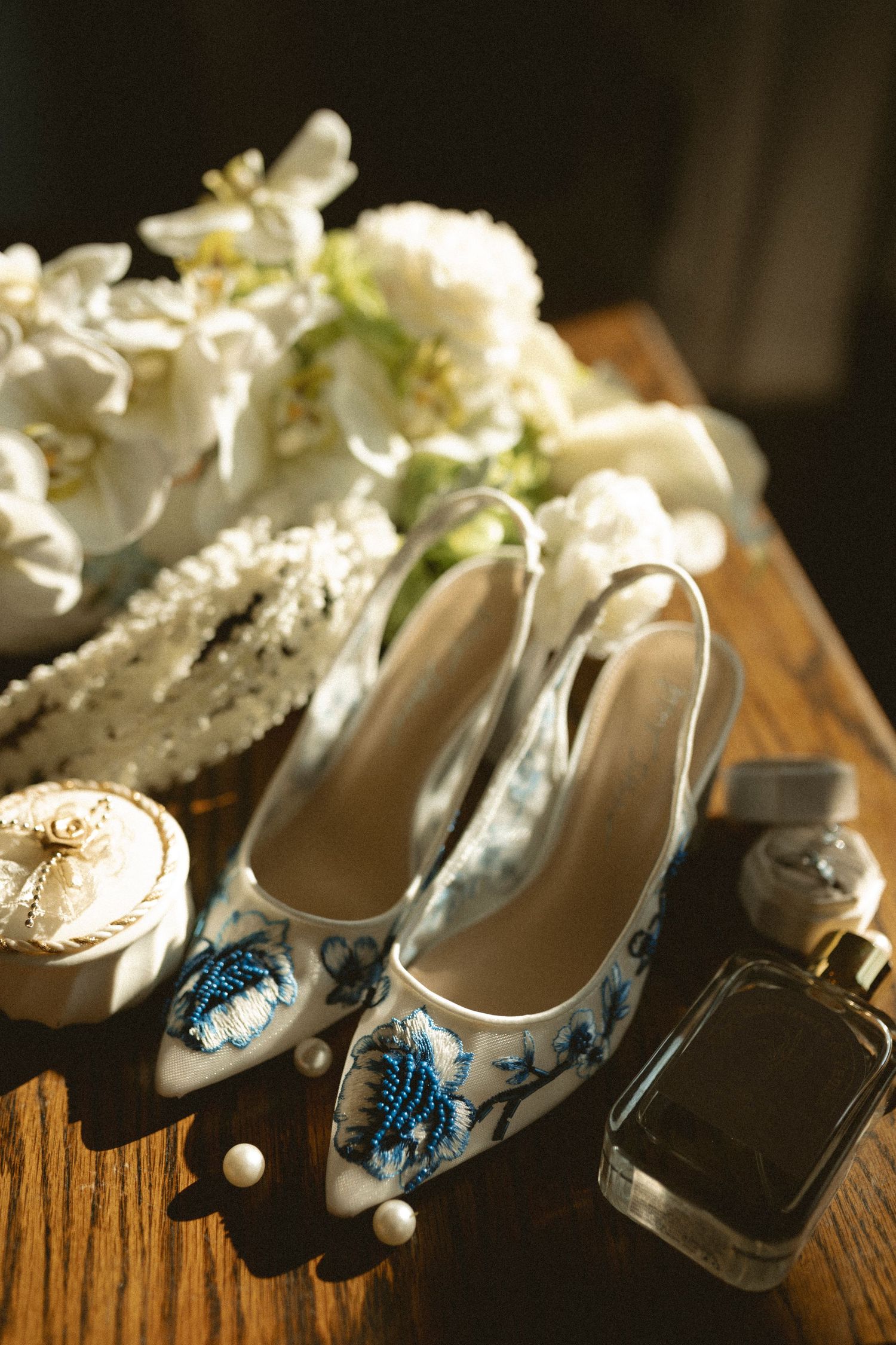 Close up detail of elegant bridal shoes and dress with lace details on stone stairs.