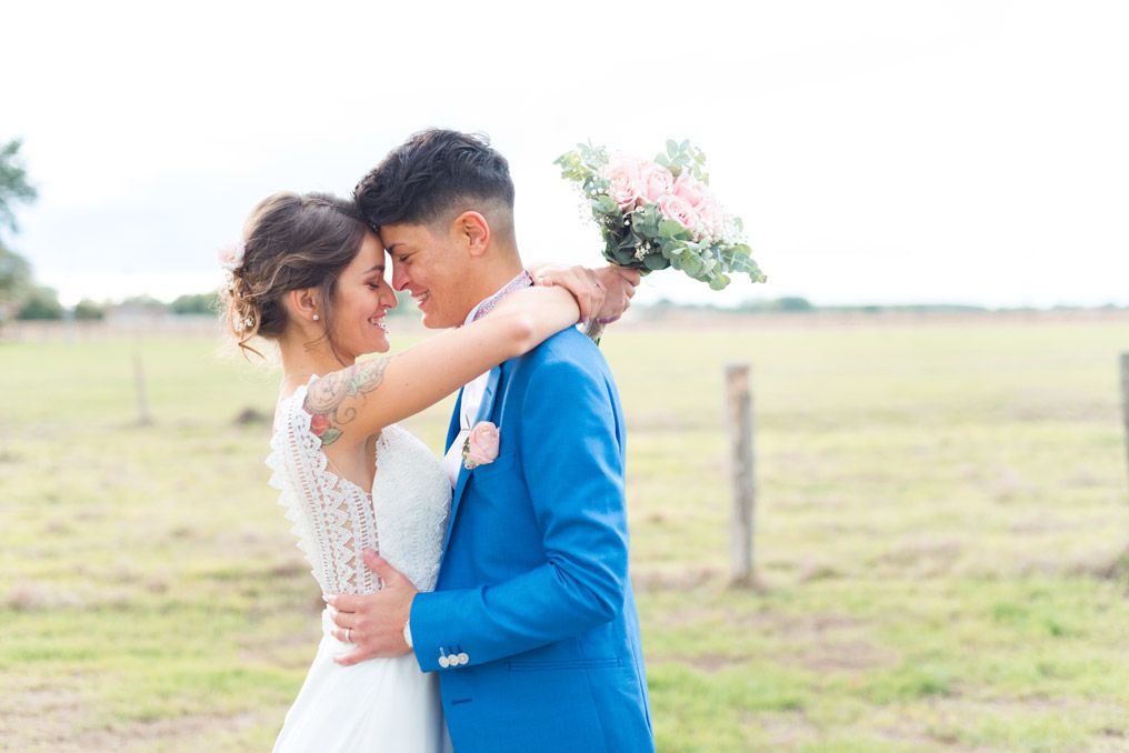 shooting photo de couple de mariage la mariee en robe blanche et le marie en costume bleu