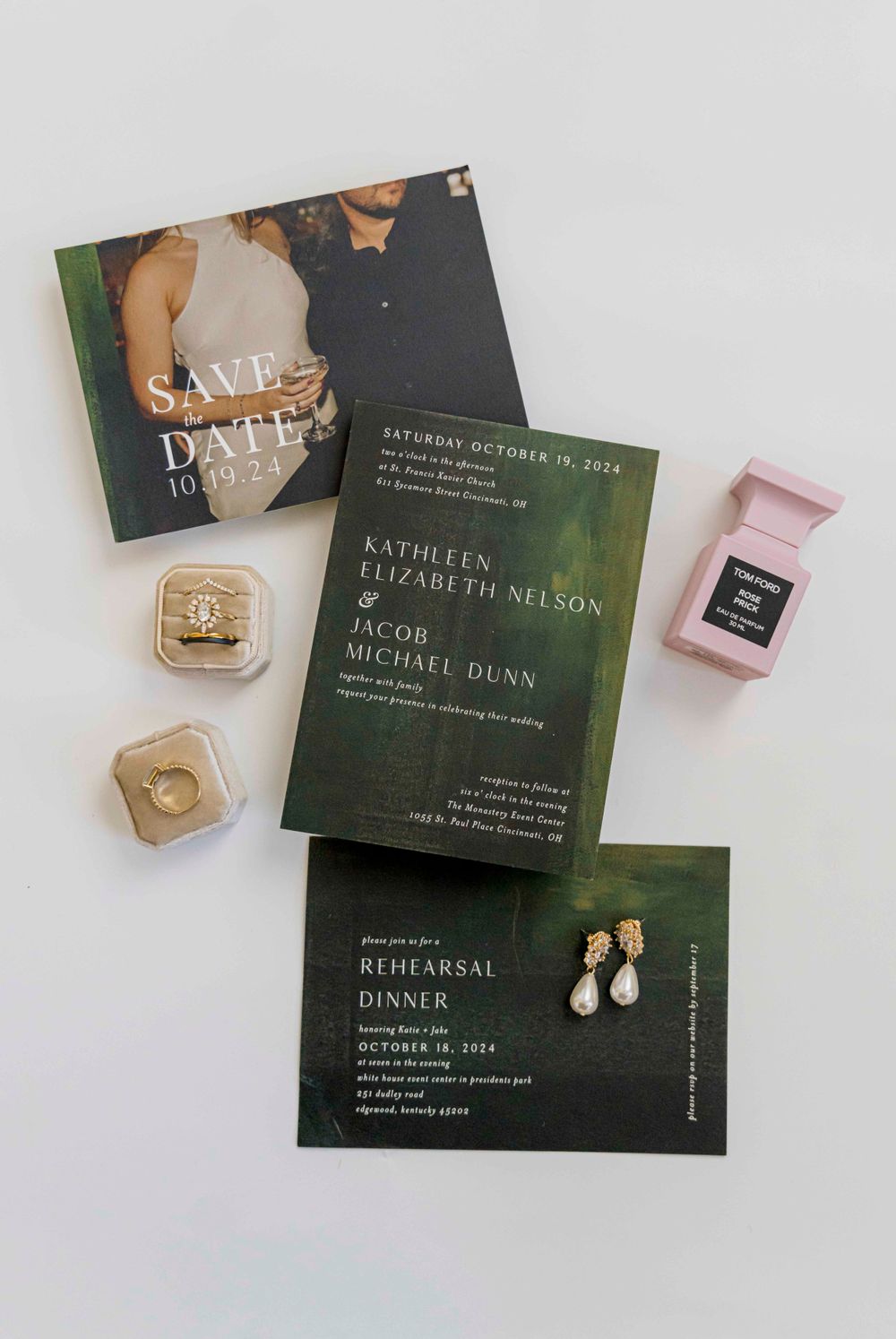 Wedding stationery suite featuring dark green invitations and ring boxes.