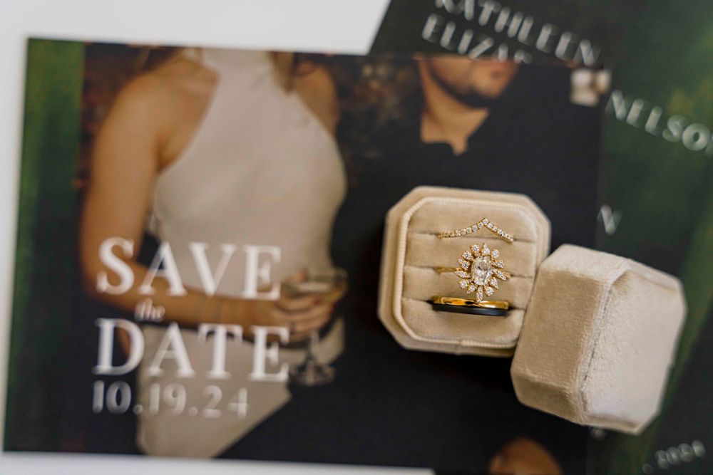 Engagement ring in velvet box displayed with save the date card.