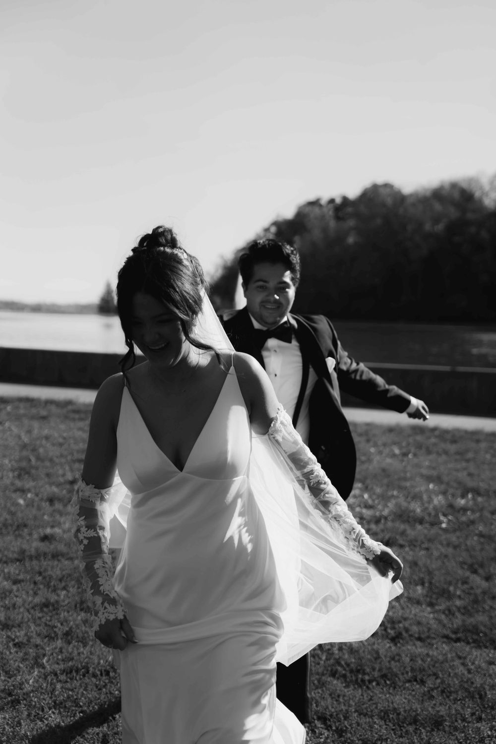 Black and white candid wedding photo in an outdoor setting.