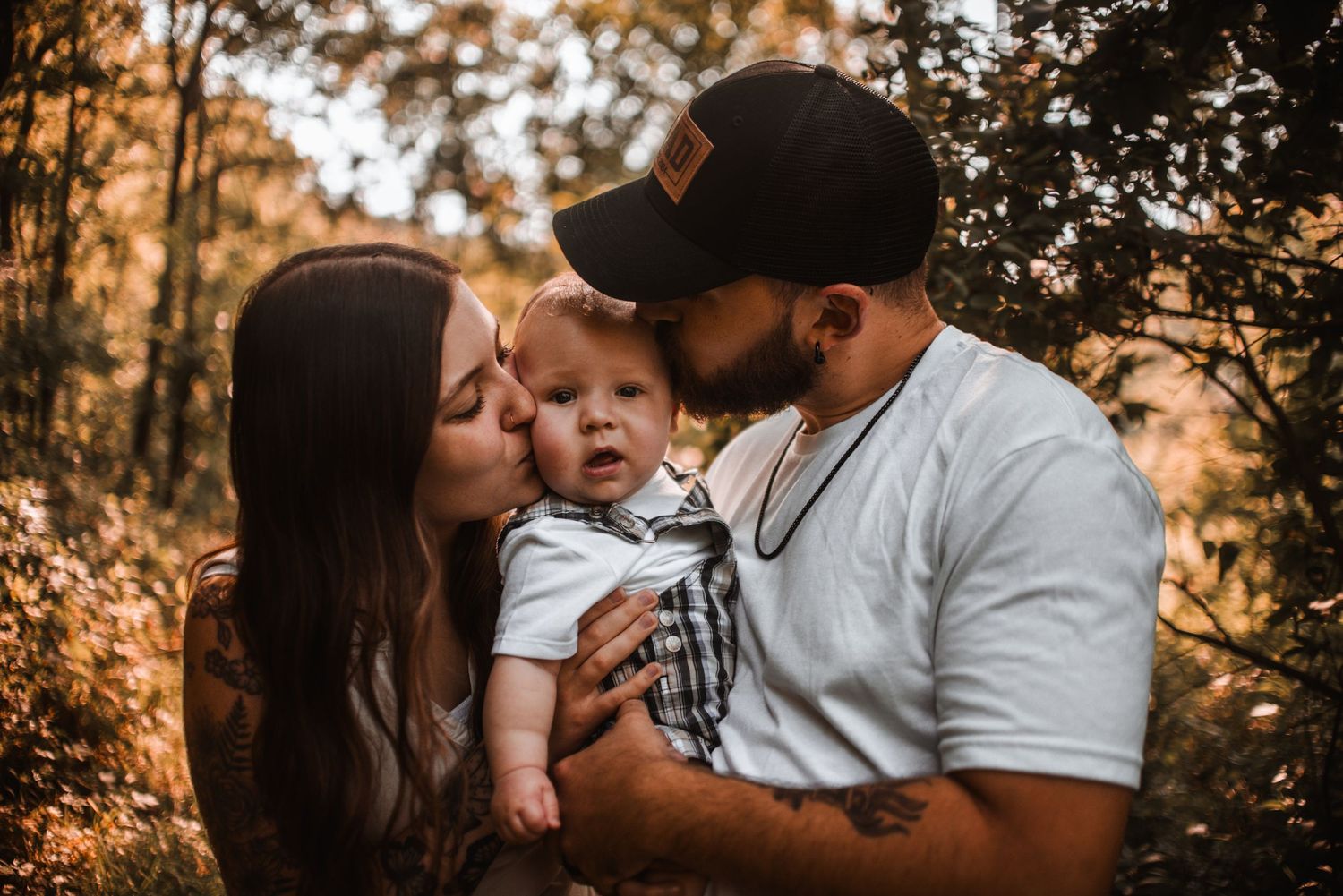 A tender family moment captured during golden hour in an autumn forest setting.