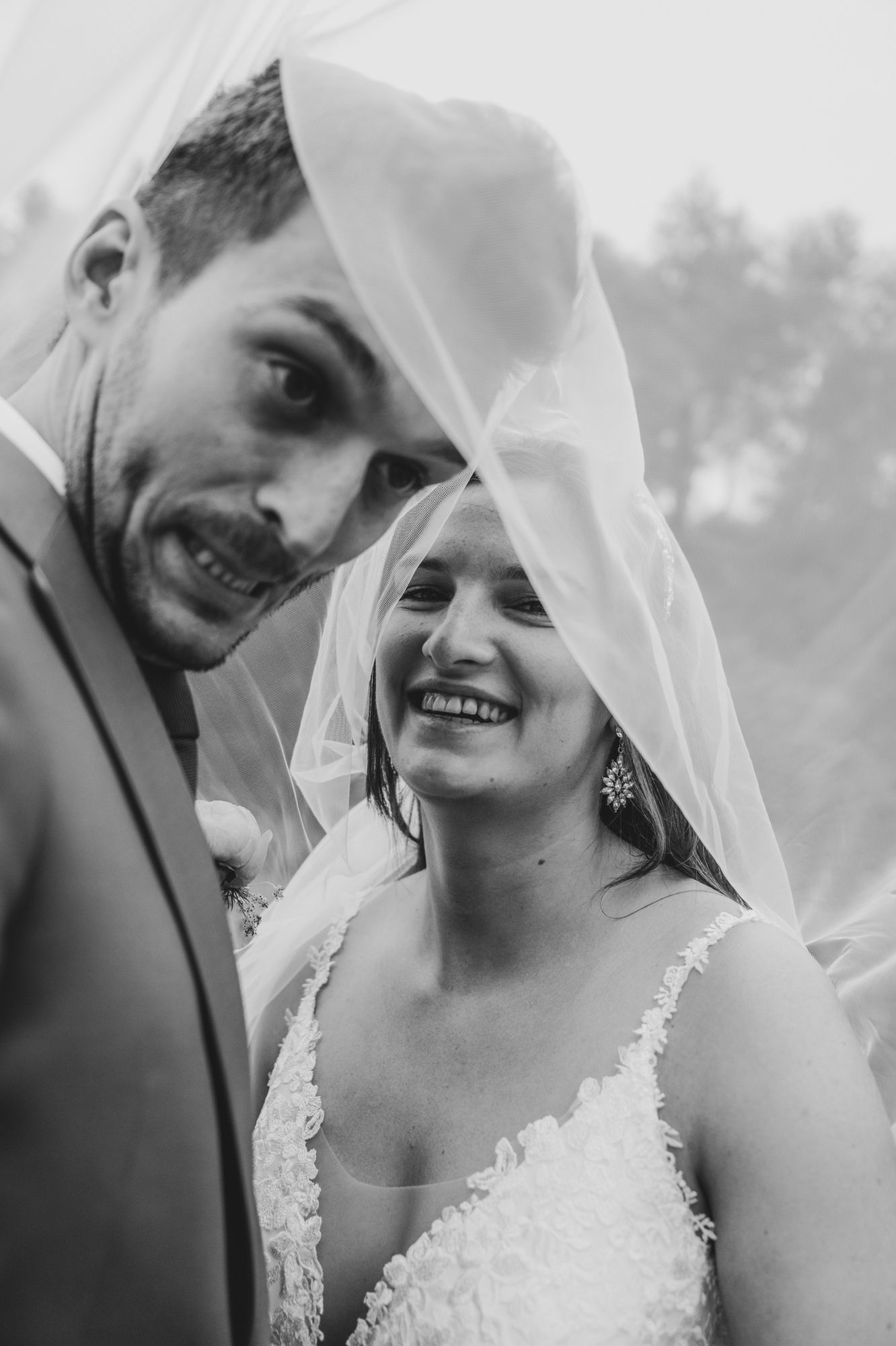 Huwelijksfotograaf Bart Boodts legt trouwkoppel vast onder sluier, spontaan, authentiek en tijdloos huwelijksmoment in zwart wit.