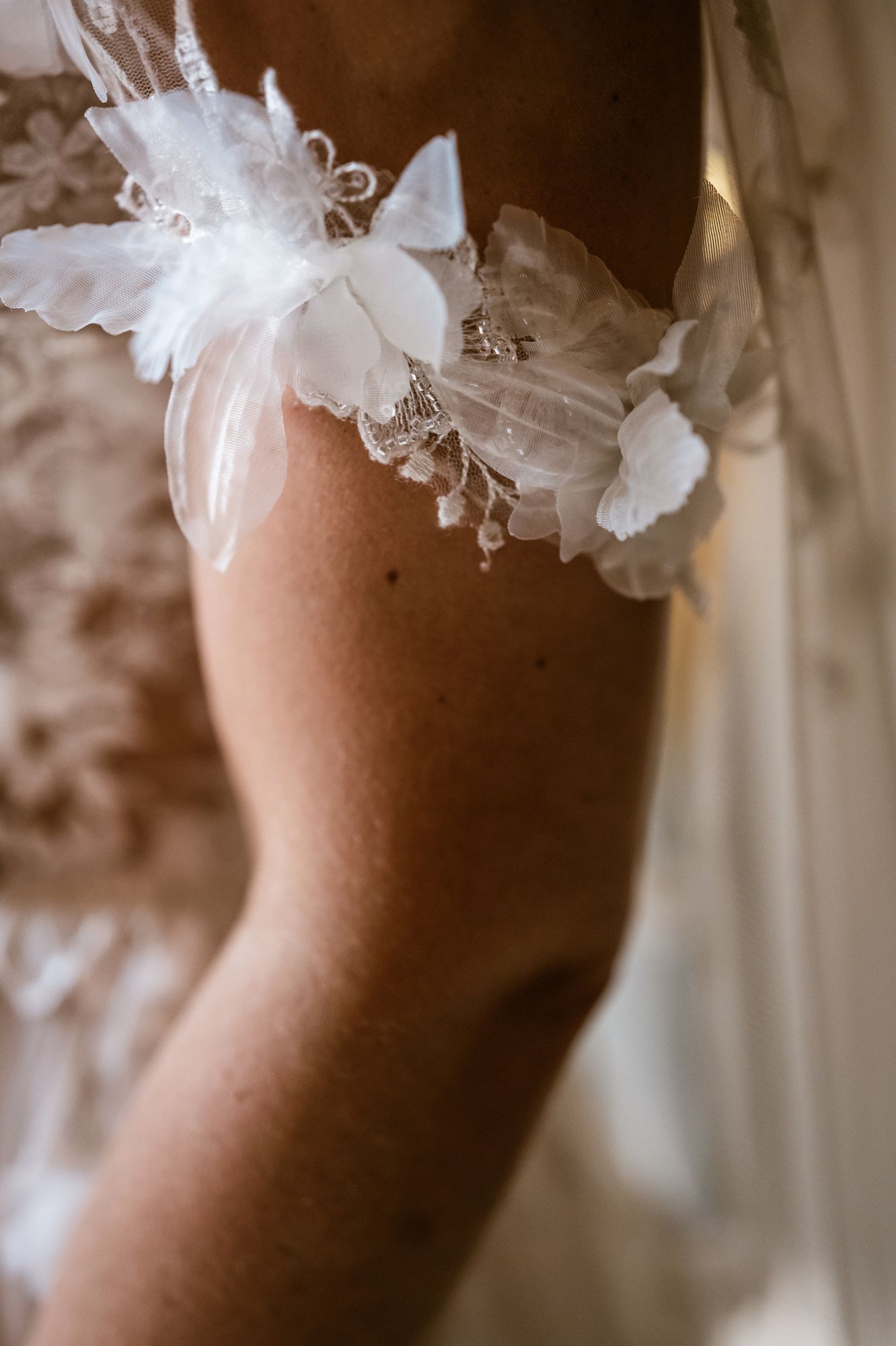 Detail van bruidskousenband met bloemen, intiem en tijdloos vastgelegd door huwelijksfotograaf Bart Boodts voor authentieke trouwreportage.