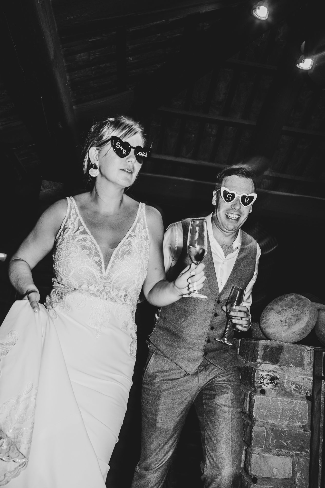 Trouwkoppel feest met zonnebrillen en champagne, spontane en authentieke foto vastgelegd door huwelijksfotograaf Bart Boodts Photography