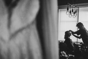 Artistiek zwart-witbeeld van een bruid tijdens make-up door visagiste Julie Campaert in Niel, vastgelegd door Bart Boodts Photography