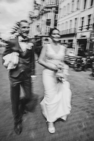 Trendy bruidspaar wandelt door Antwerpen, dynamisch vastgelegd door Bart Boodts, huwelijksfotograaf met artistieke visie
