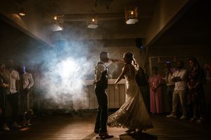 Bruidspaar danst hun openingsdans bij Strantwerpen in sfeervol licht en rook, vastgelegd door huwelijksfotograaf Bart Boodts