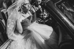 Bruid geniet van het zonlicht in een cabrio in Niel, sfeervol vastgelegd door Bart Boodts, huwelijksfotograaf met emotie en stijl